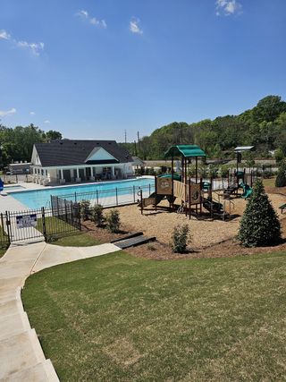 A beautiful community pool and playground area in Diamante by DRB Homes, nestled in Stockbridge, GA.