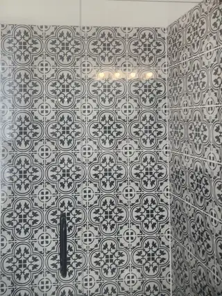 Model Home An elegant bathroom with patterned black and white tiles creating a stylish and sophisticated atmosphere.