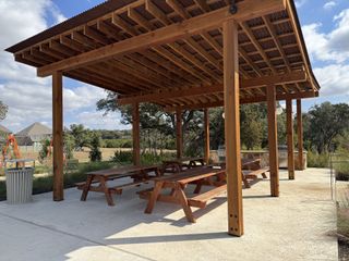 Community Amenities A charming outdoor pavilion with wooden picnic tables in Wolf Ranch - 60' by Drees Custom Homes (Georgetown, TX).