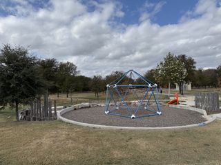A charming park with playground and trees in the Village at Manor Commons by Landsea Homes (Manor, TX).