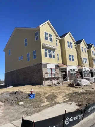 Street view New construction of yellow townhomes in Village Club at Wescott by Ashton Woods (Summerville, SC).