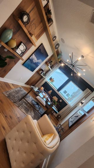 A cozy home office with built-in wooden shelving, stylish decor, and a statement chandelier for a productive workspace.