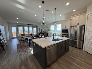 Kitchen – A stunning kitchen with white cabinetry, quartz countertops, and pendant lighting.
