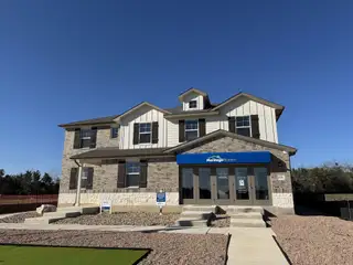 A beautiful two-story home with brick and siding exterior in Opal Meadows by Meritage Homes (Kyle, TX).