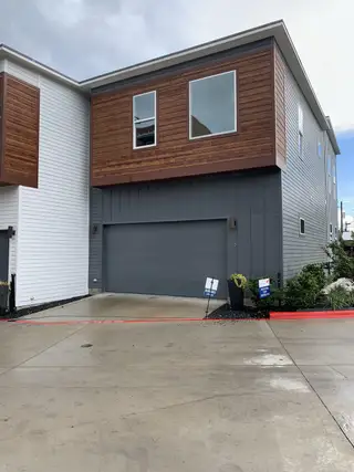 Street view Modern townhome with sleek wood accents and a spacious garage in Bluebonnet Lofts by InTown Homes (Austin, TX).