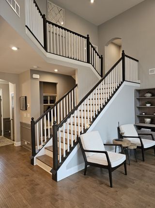 A grand staircase with dark wood accents, white balusters, and an open-concept landing, adding a touch of elegance.