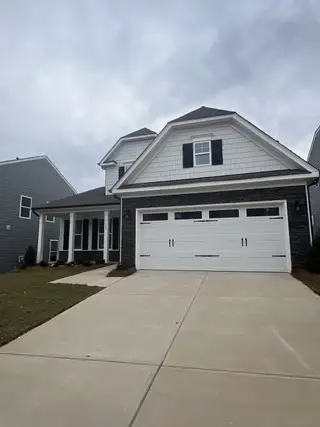 A charming home with a gabled roof and spacious driveway in Summerlin by Eastwood Homes (Mooresville, NC).