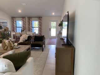 A cozy living area with elegant decor, featuring plush seating, chic curtains, and abundant natural light.