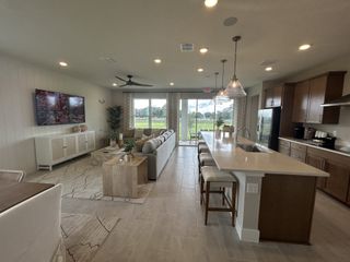 Spacious open-concept living area with elegant kitchen, modern furnishings, and serene outdoor view.