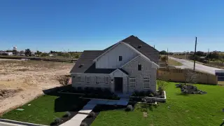 A charming brick home with a manicured lawn in Calumet by Brightland Homes (Jarrell, TX).