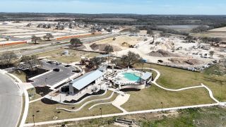 Community amenities and ongoing development in Lariat 60' by Coventry Homes, Liberty Hill, TX, featuring a central pool.