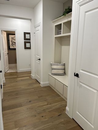 A cozy hallway with light wood flooring, built-in storage, and elegant white doors for a modern touch.