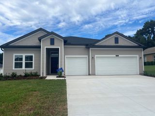 A charming single-story home with dual garages and manicured landscaping in Grand Park North by Lennar (Dunnellon, FL).