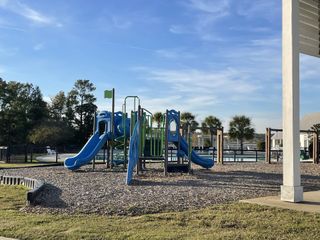 A vibrant playground with slides and a pool in Recess Pointe Townhomes by DRB Homes (Moncks Corner, SC).