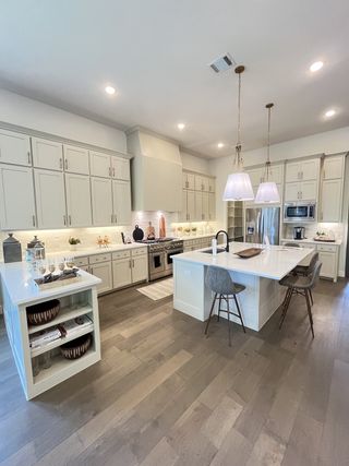 Model Home A modern kitchen with a large island, pendant lighting, and sleek cabinetry.