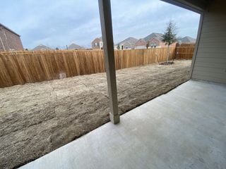 A peaceful backyard with a wood fence and fresh sod in Shaded Tree by Lennar (McKinney, TX).