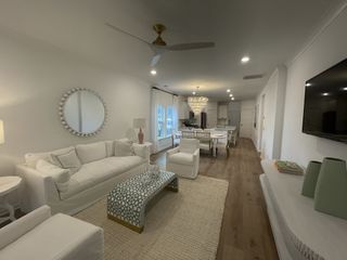 A stylish living area with a cozy white sofa, chic coffee table, and elegant chandelier, offering a sophisticated ambiance.