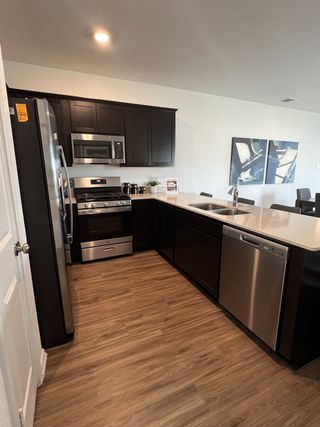 A sleek kitchen design featuring dark cabinetry, stainless steel appliances, and a spacious island, blending modern style with functionality.