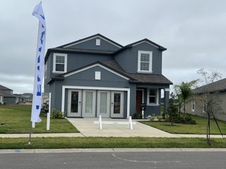 A stylish new two-story home with a dark blue exterior and inviting entryway in Mirada by Lennar (San Antonio, FL).