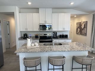 Model Home A bright open-concept kitchen, dining, and living space with lake views in Kings Crossing by Meritage Homes (Jacksonville, FL).