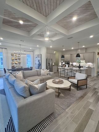 Spacious open-concept living area with modern furnishings, textured ceilings, and stylish lighting.