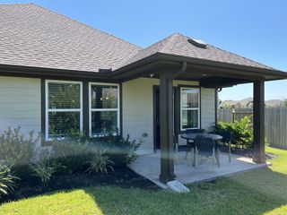 A charming patio area with cozy seating, nestled in Massey Oaks - Estate Series by Meritage Homes (Pearland, TX).