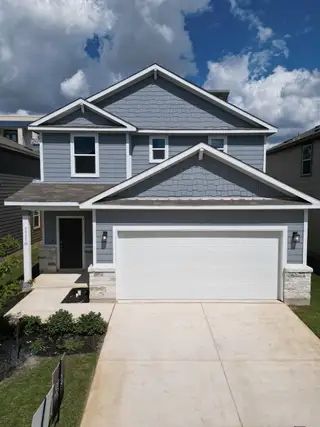 Street view A modern gray home with a two-car garage and tidy landscaping in University Village by Century Communities (San Antonio, TX).