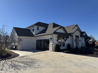 Street view A beautifully designed modern farmhouse with stone and wood accents in North Haven by GFO Home (Liberty Hill, TX).