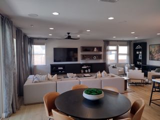 A modern living room with cozy seating, large TV, sleek shelving, and contemporary decor.