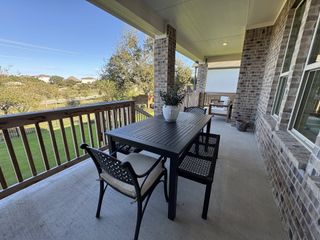 A cozy outdoor patio with brick accents, seating, and lush views, ideal for relaxation and gatherings.