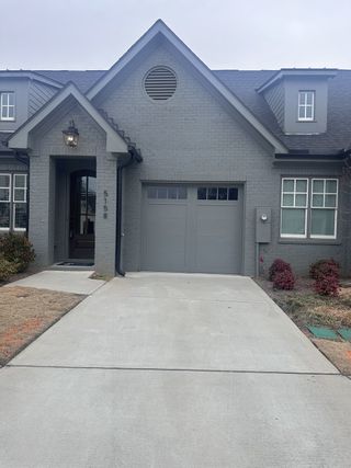 Street view A charming gray brick home with classic design in Cottages at Noble Village by Seed Capital Investments, LLC (Lilburn, GA).