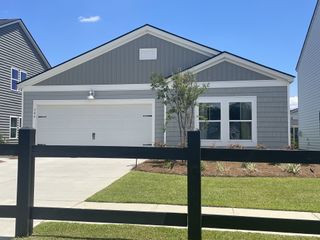 A modern gray siding home with white trim and a neat lawn in Cypress Preserve: American Dream Series by Lennar (Moncks Corner, SC).