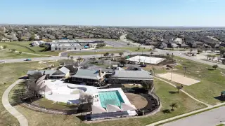 Community Amenities Spacious community pool and recreational area at Blackhawk by Chesmar Homes in Pflugerville, TX, surrounded by lush landscape.
