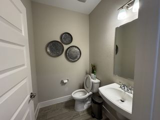 A sleek bathroom with a modern sink, wall decor, and warm lighting, creating a cozy and inviting atmosphere.