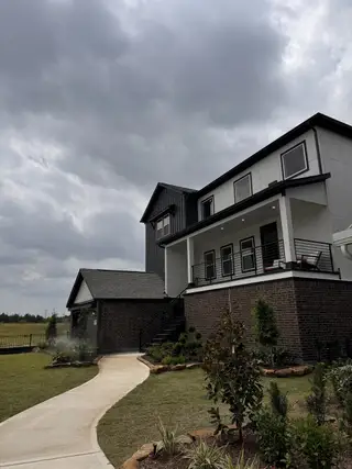 Street view A modern two-story home with brick and siding in Townsen Landing by Saratoga Homes (Humble, TX).