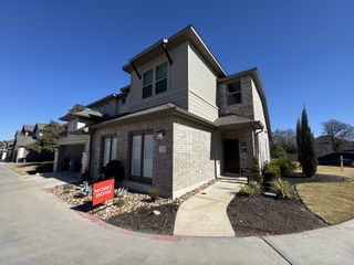 A modern brick home with landscaped yard in Sonoma Heights by Coventry Homes (Round Rock, TX).