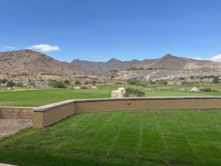 Stunning mountain views with a lush green lawn in Four Seasons at Victory at Verrado by K. Hovnanian® Homes (Buckeye, AZ).