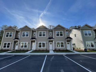 Street view Modern townhomes with gabled roofs and neat lawns in Twin Rivers Towns by Prosperity Builders (Charleston, SC).