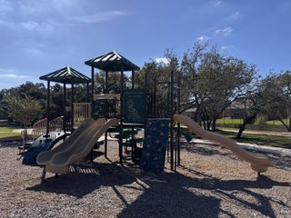 Community Amenities A vibrant playground with slides and climbing structures in Highland Village by Coventry Homes (Georgetown, TX).
