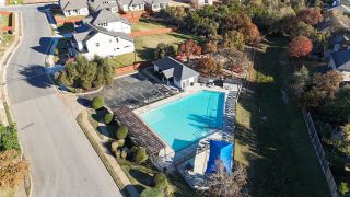 Inviting community pool with pergola and playground in Sauls Ranch East by Coventry Homes (Round Rock, TX).
