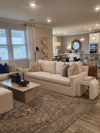 A warm and inviting living room featuring plush seating, soft textures, and sophisticated decor elements, designed for both relaxation and entertaining.