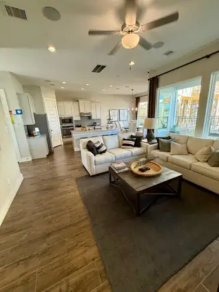 Model Home Open-concept living with wood-look tile, flowing from the kitchen to the living area.