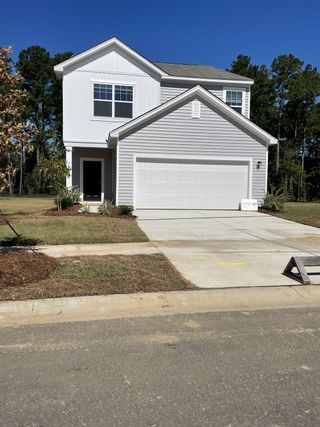 Street view A modern gray siding home with a clean driveway in Watson Hill by Starlight Homes, Summerville, SC.