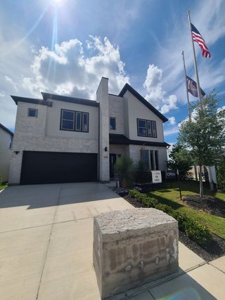 Street view A contemporary two-story home featuring sleek architecture and lush landscaping in Madero by Trophy Signature Homes (Haslet, TX).