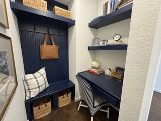 A cozy nook with navy built-ins, wicker baskets, and decorative accents, perfect for a home office or reading space.