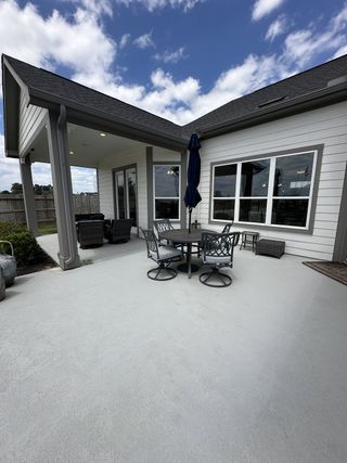 Street view A spacious patio with cozy seating, a round table, and umbrella under a clear blue sky. Perfect for relaxing or entertaining.