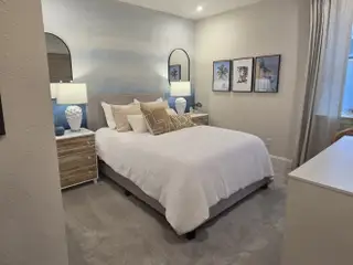 Model Home A cozy bedroom featuring soft hues, elegant decor, and stylish lighting, creating a serene and inviting atmosphere.