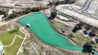 Community Amenities A serene turquoise pond with a dock in at Lariat by Ashton Woods, Liberty Hill, TX.
