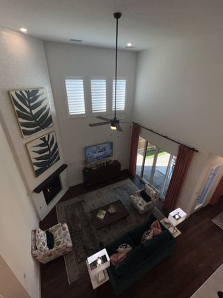 A grand two-story living room with high ceilings, fireplace, and elegant décor.