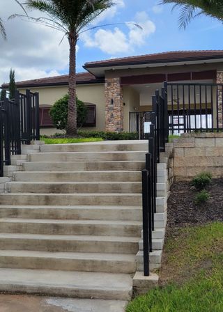 Elegant modern home with stone accents and lush landscaping in Ridgeview by Trinity Family Builders (Clermont, FL).